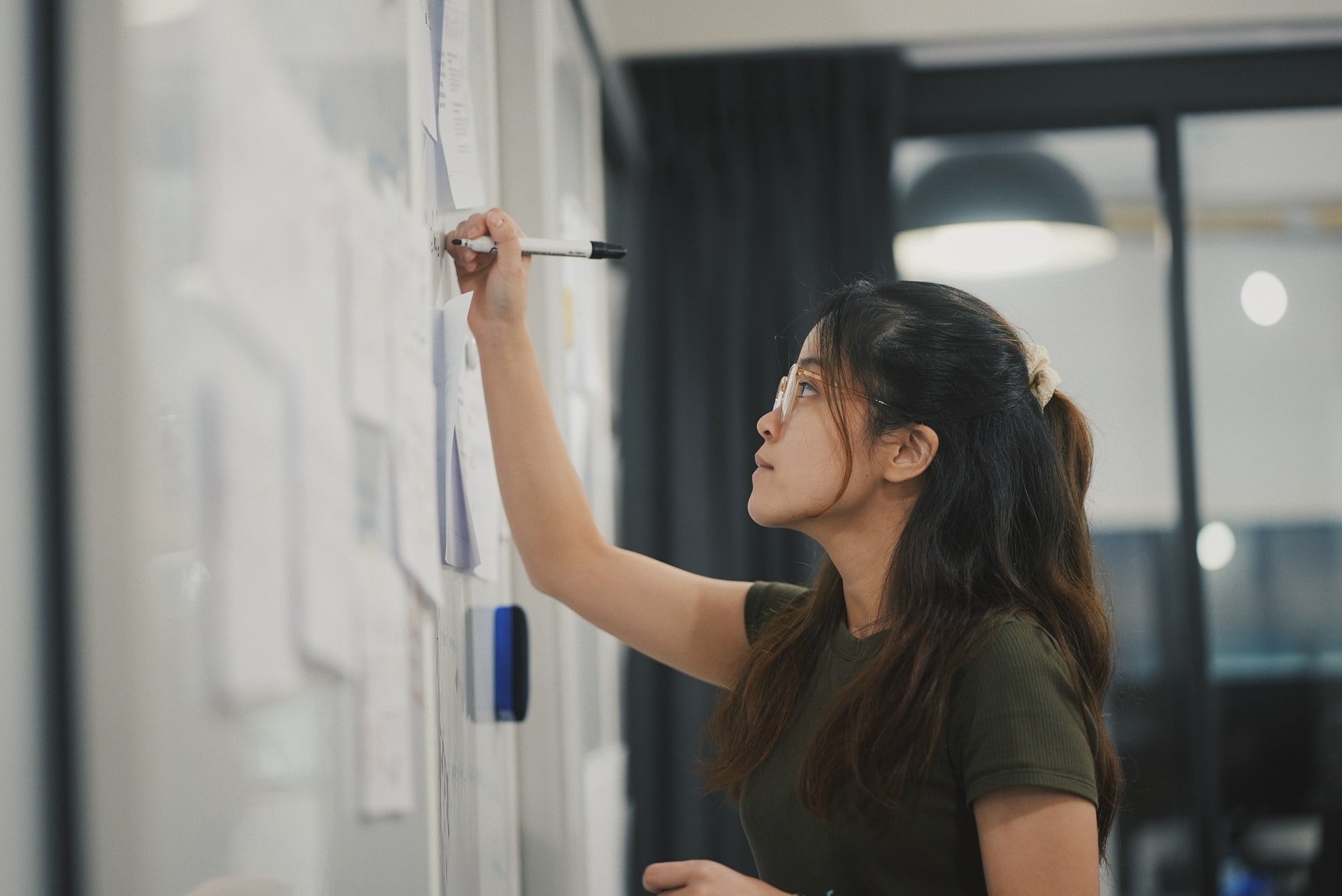 Woman writing on whiteboard